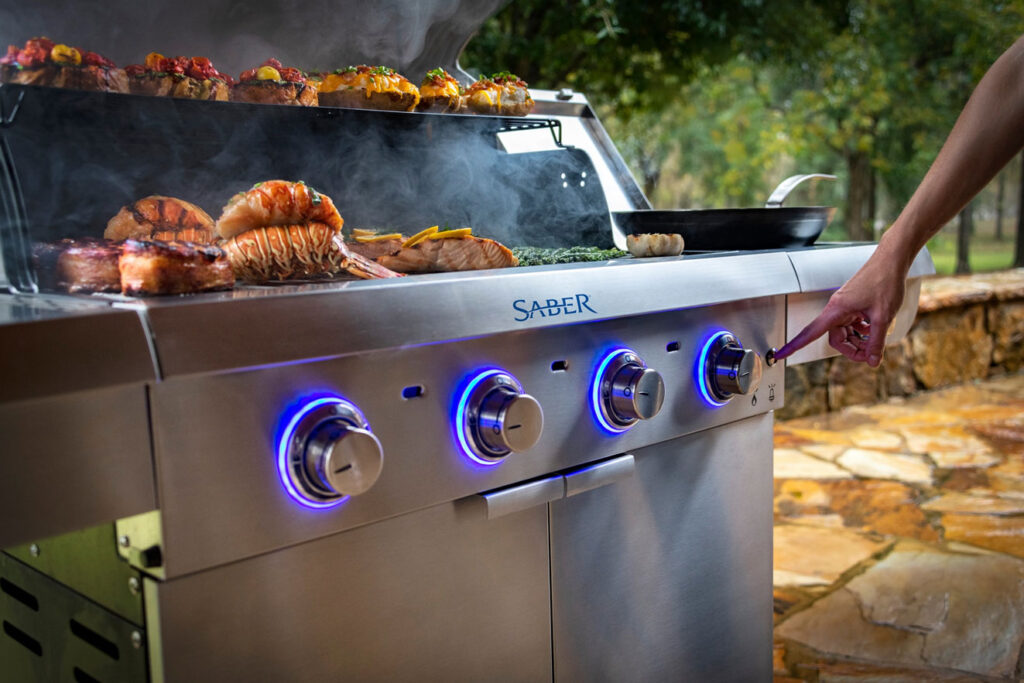 Saber infrared gas grill cooking meats and lobster outdoors