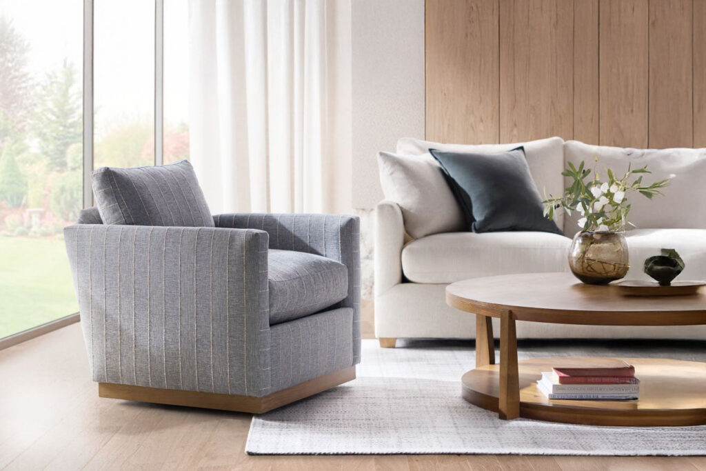 Modern gray upholstered swivel chairs in a bright living room with wood coffee table and neutral sofa