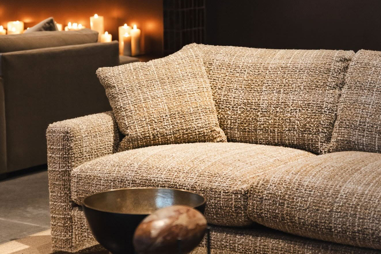 Textured beige boucle sofa with matching throw pillow on display at Fowler Brothers Co furniture showroom in Chattanooga TN.