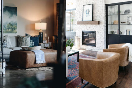 Cozy living room with leather furniture including brown leather ottoman and modern leather chairs in front of fireplace