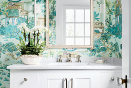 Elegant bathroom featuring Thibaut Wallpaper with a botanical and architectural design, paired with a white vanity and gold-framed mirror